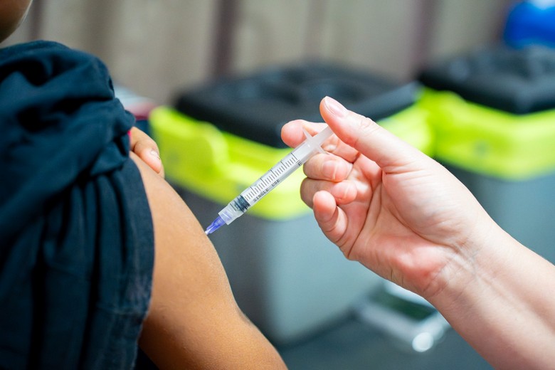 Aplicação de vacina no braço de uma pessoa